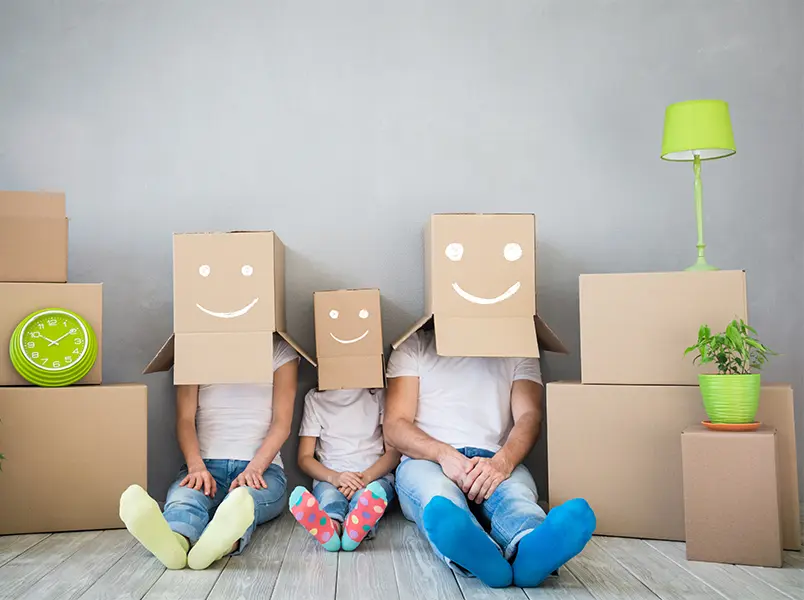 Family preparing for a long distance move with packing boxes and playful smiles