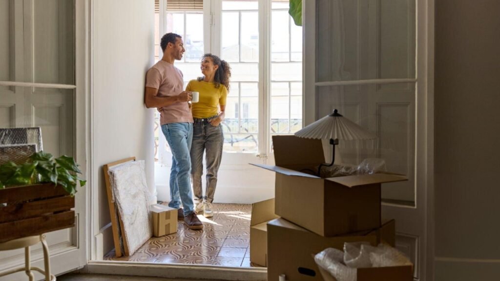 Couple taking a break in their new house after using house moving apps