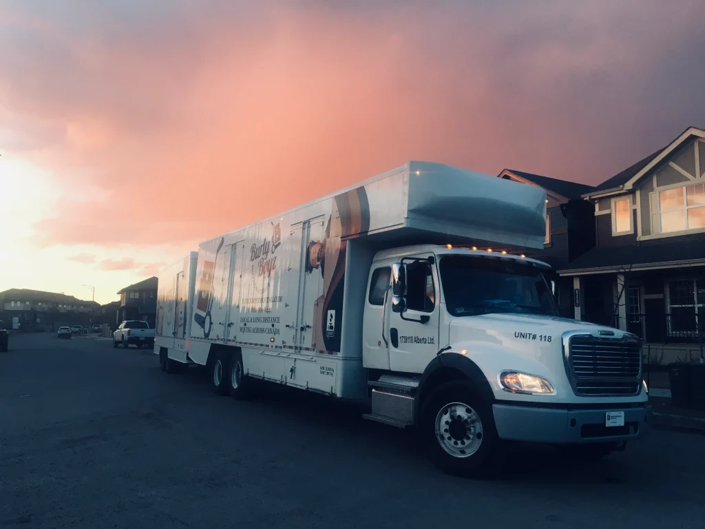Truck from Burly Boyz, affordable long distance movers in Canada, parked in a residential area at sunset