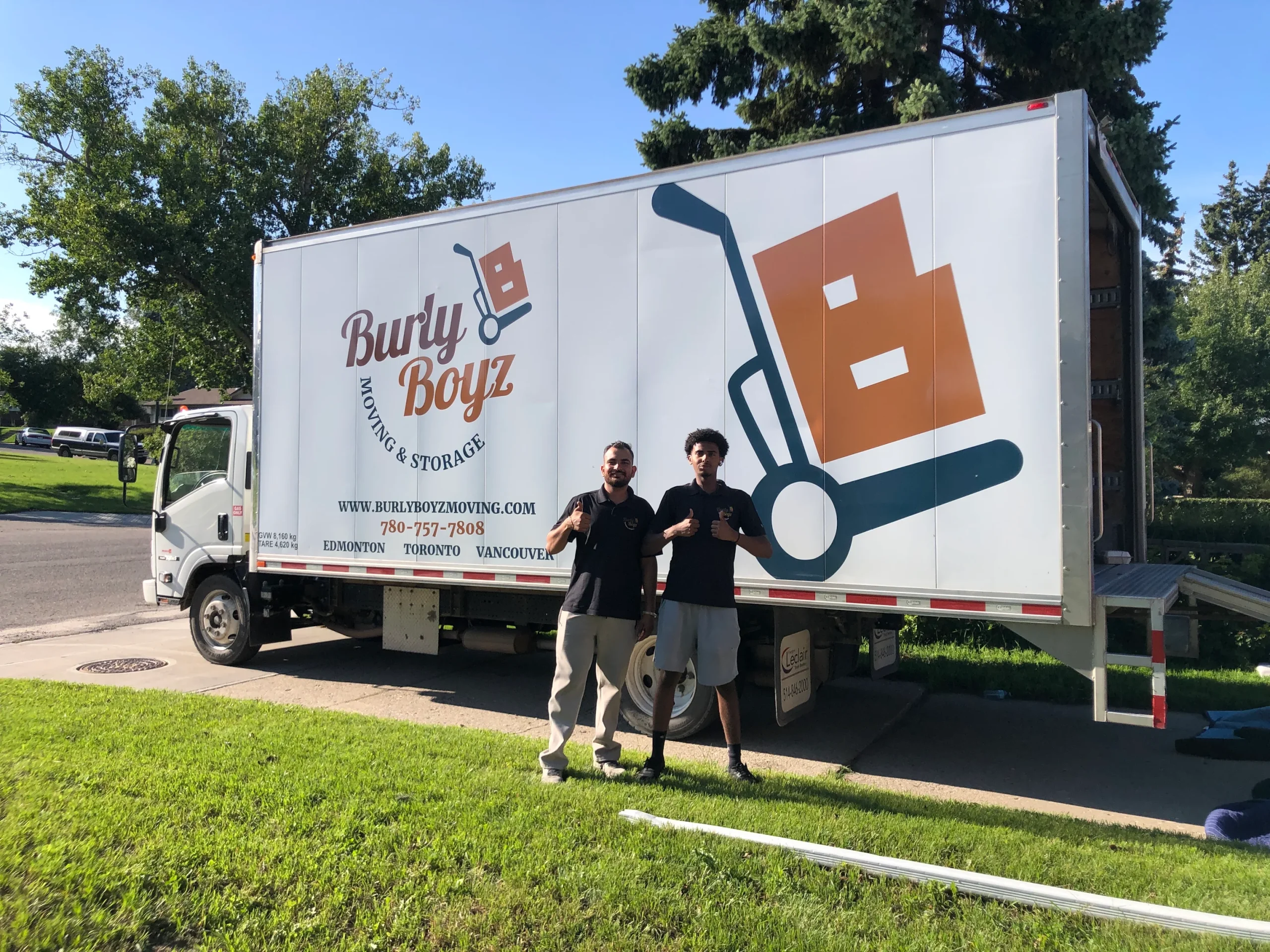 Burly Boyz cross Canada moving company team standing in front of a moving truck after completing a long-distance relocation.